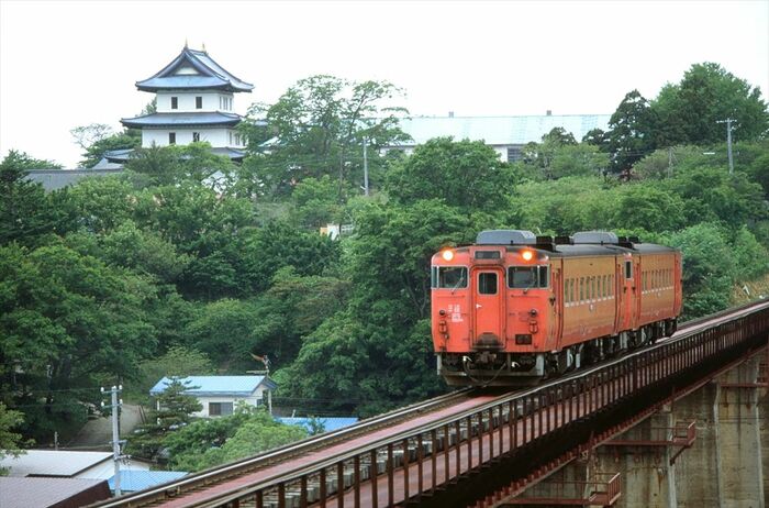 松前城をバックに走る松前線の列車