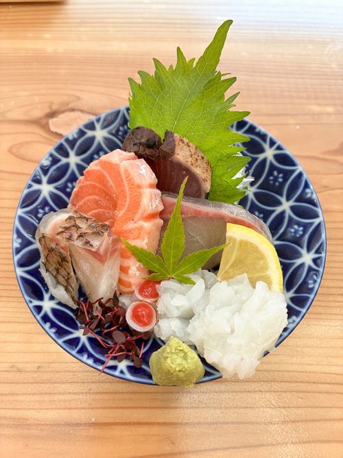 津本社長に刺身についてお聞きしていたところ、「とにかく食べてや」と突然サービスしてくれたオリジナルの盛り合わせ。上から時計回りに、カツオ、カンパチ、生ダコの梅肉和え、タイの炙り、サーモンの5種。刺身の宝石箱 